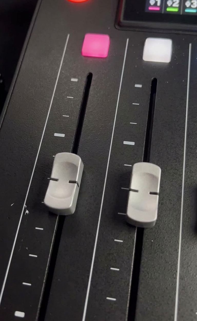 Faders d'une console de mixage, une piste son par micro