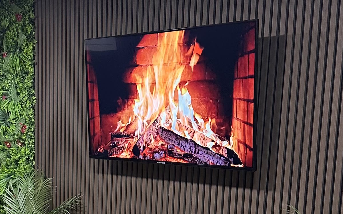 Écran d'ambiance diffusant une cheminée sur le mur de tasseaux du plateau