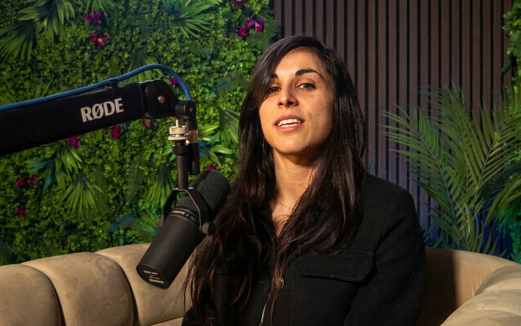 Une intervenante parle dans un micro Shure monté sur perche pendant l'enregistrement d'un podcast